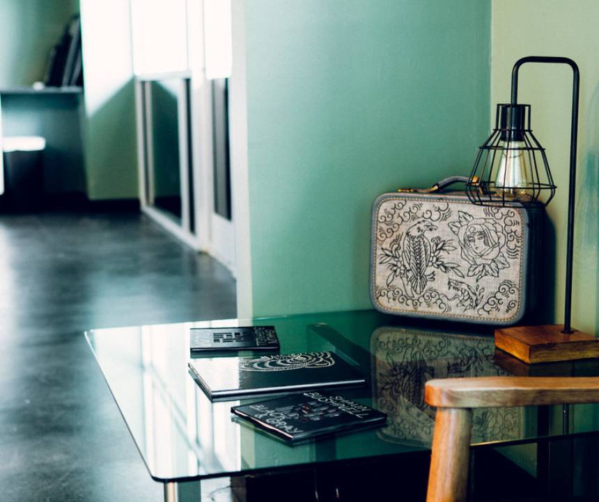 A glass table with some electronics and a suitcase