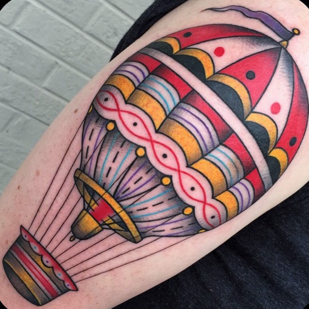 A colorful balloon tattoo is shown on the arm.