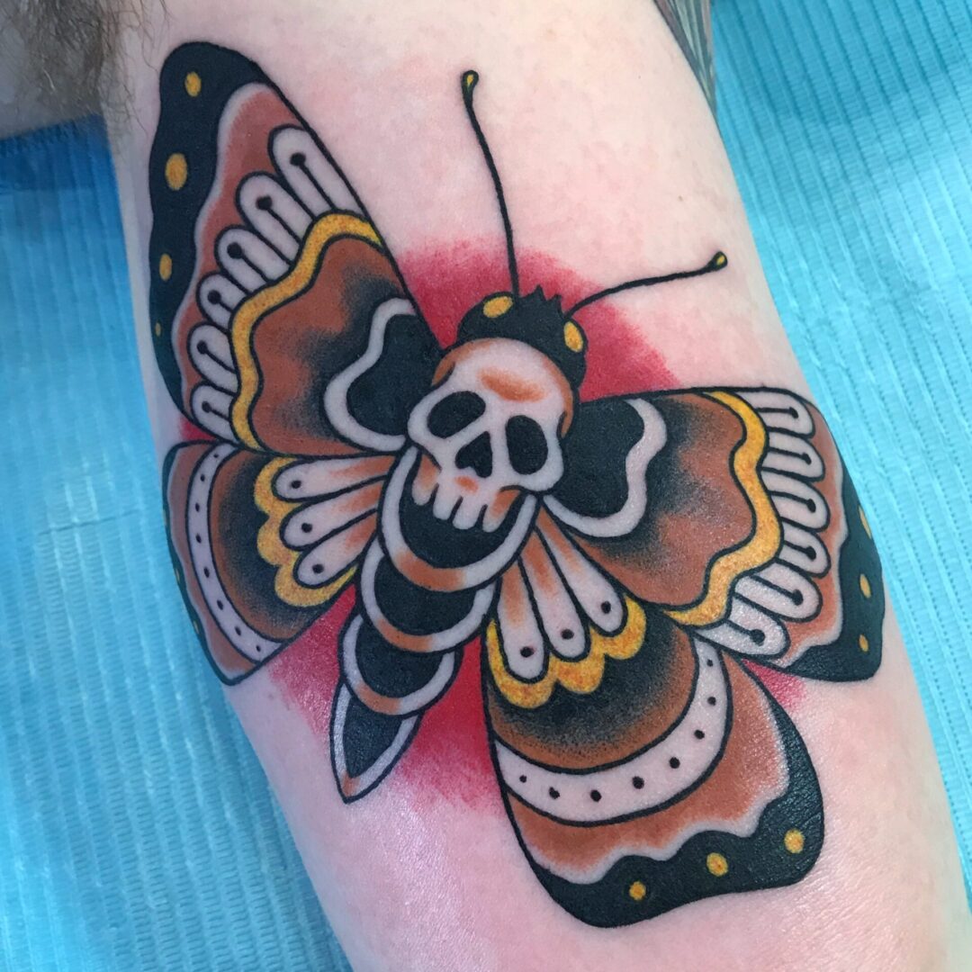 A tattoo of a butterfly with skull on it.