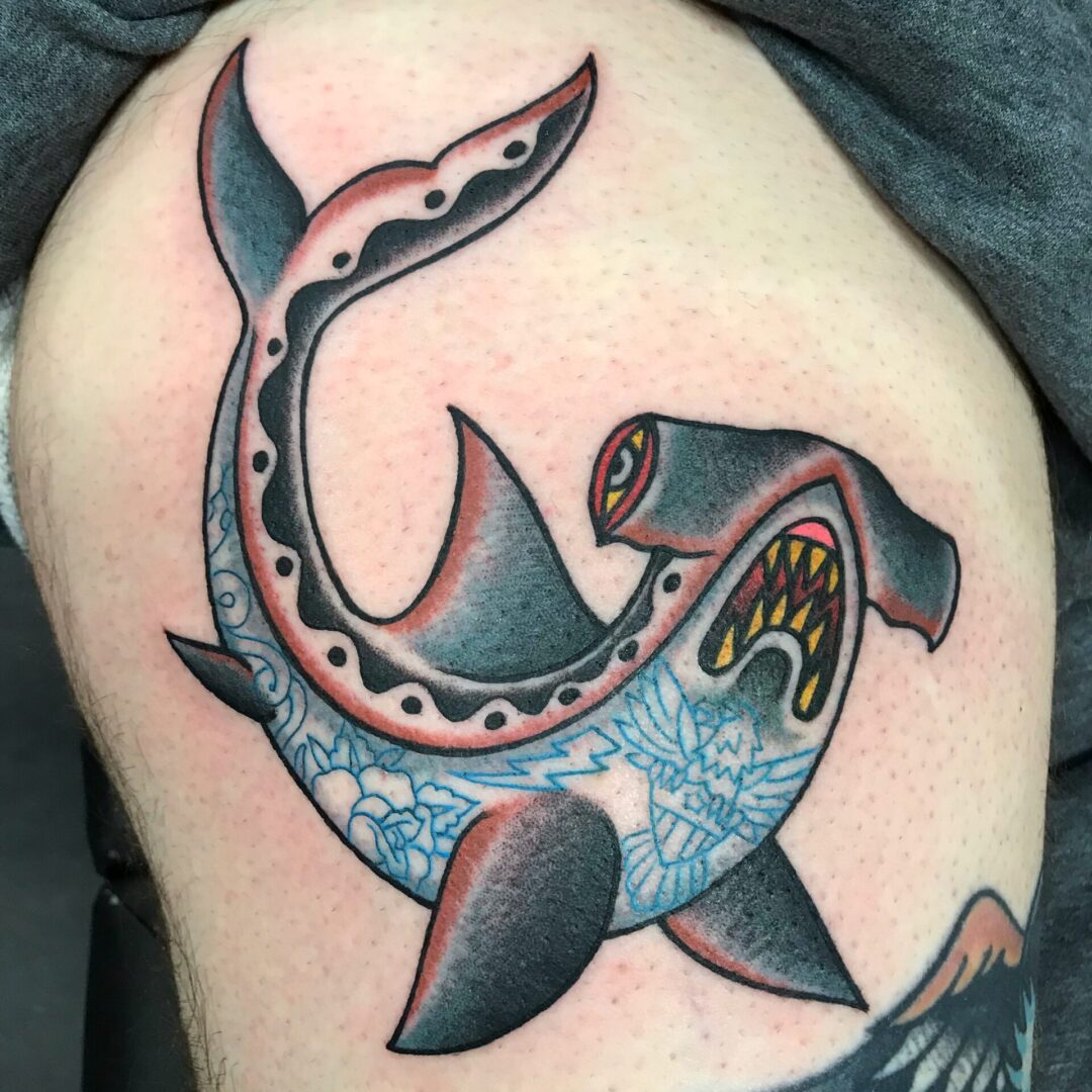 A tattoo of a shark with a fish tail.