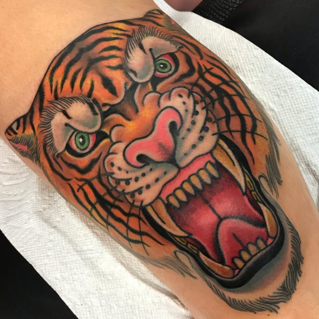 A tiger tattoo is shown on the arm of someone.