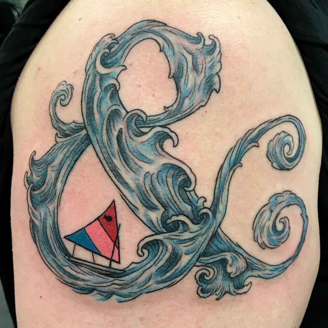 A tattoo of an ampersand with waves coming from it.