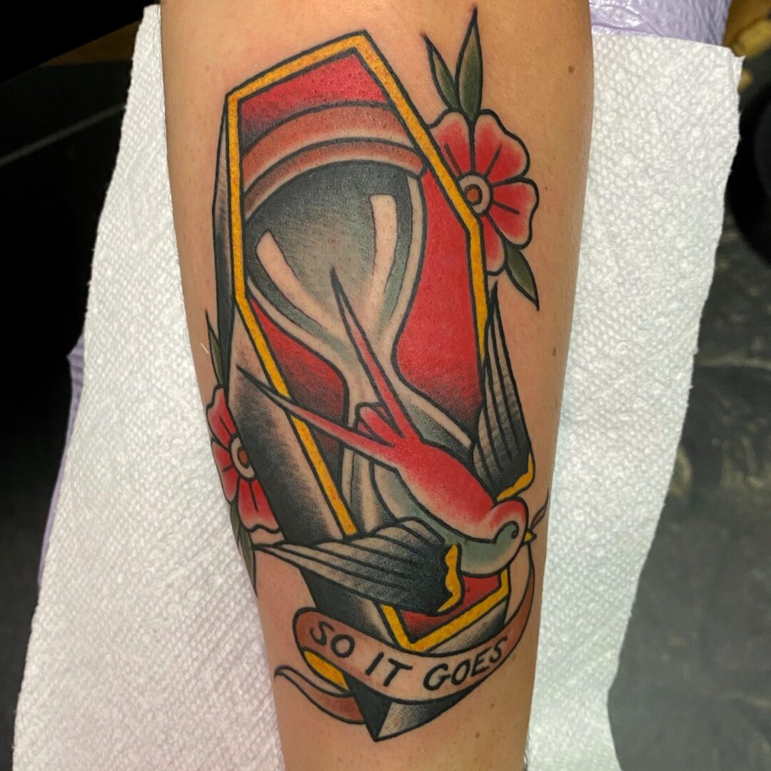 A tattoo of a fish in the shape of a coffin.