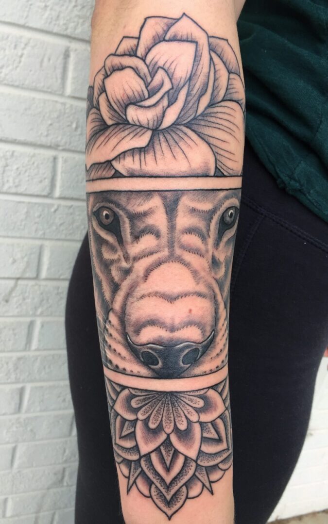 A woman with a tattoo of a dog 's face and a rose.