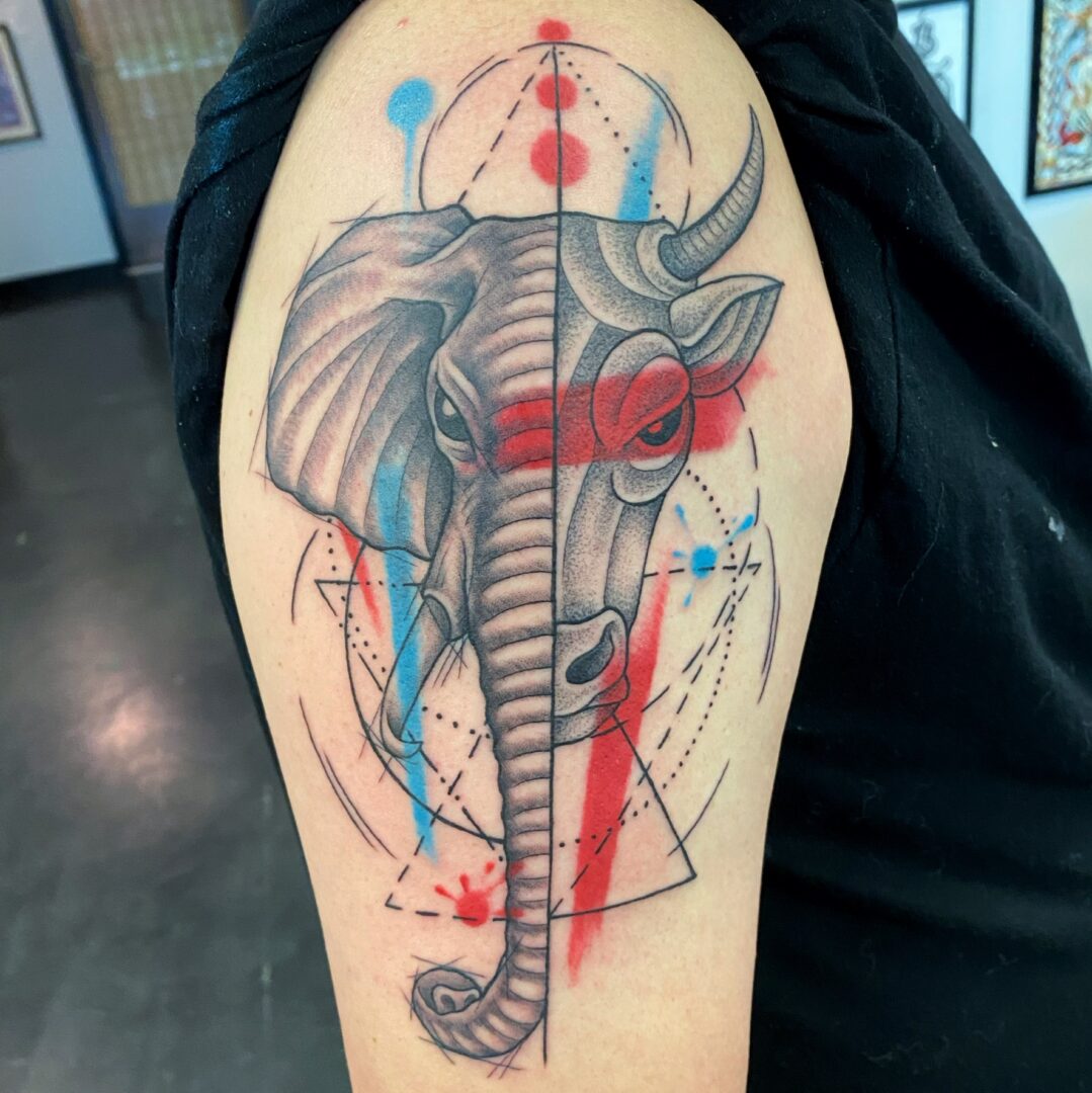 A tattoo of an elephant with red and blue accents.