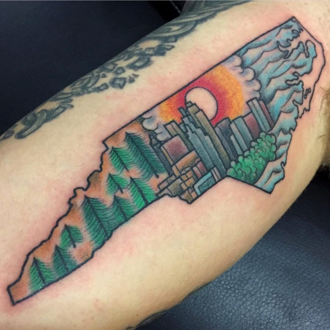 A tattoo of the state of north carolina with a sunset in the background.