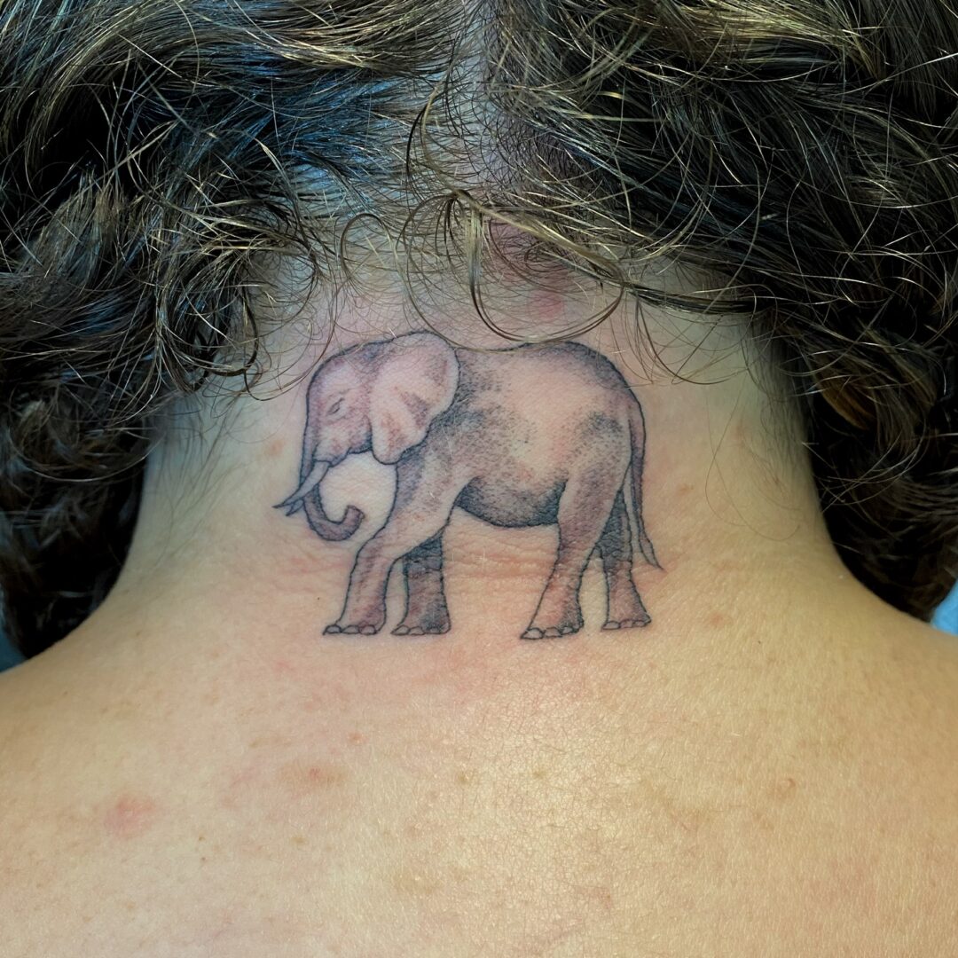 A woman with an elephant tattoo on her neck.