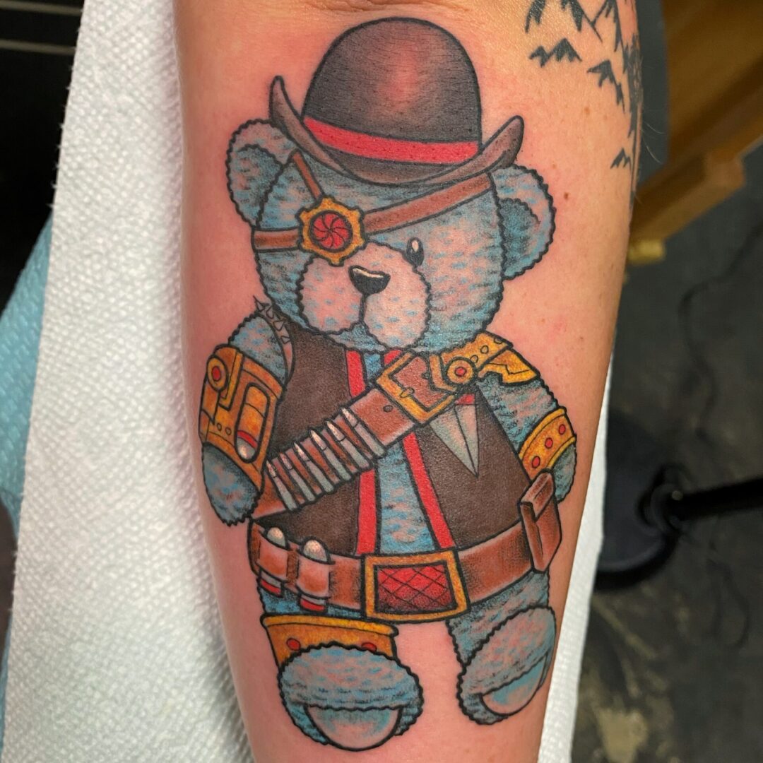 A teddy bear with a hat and vest on.