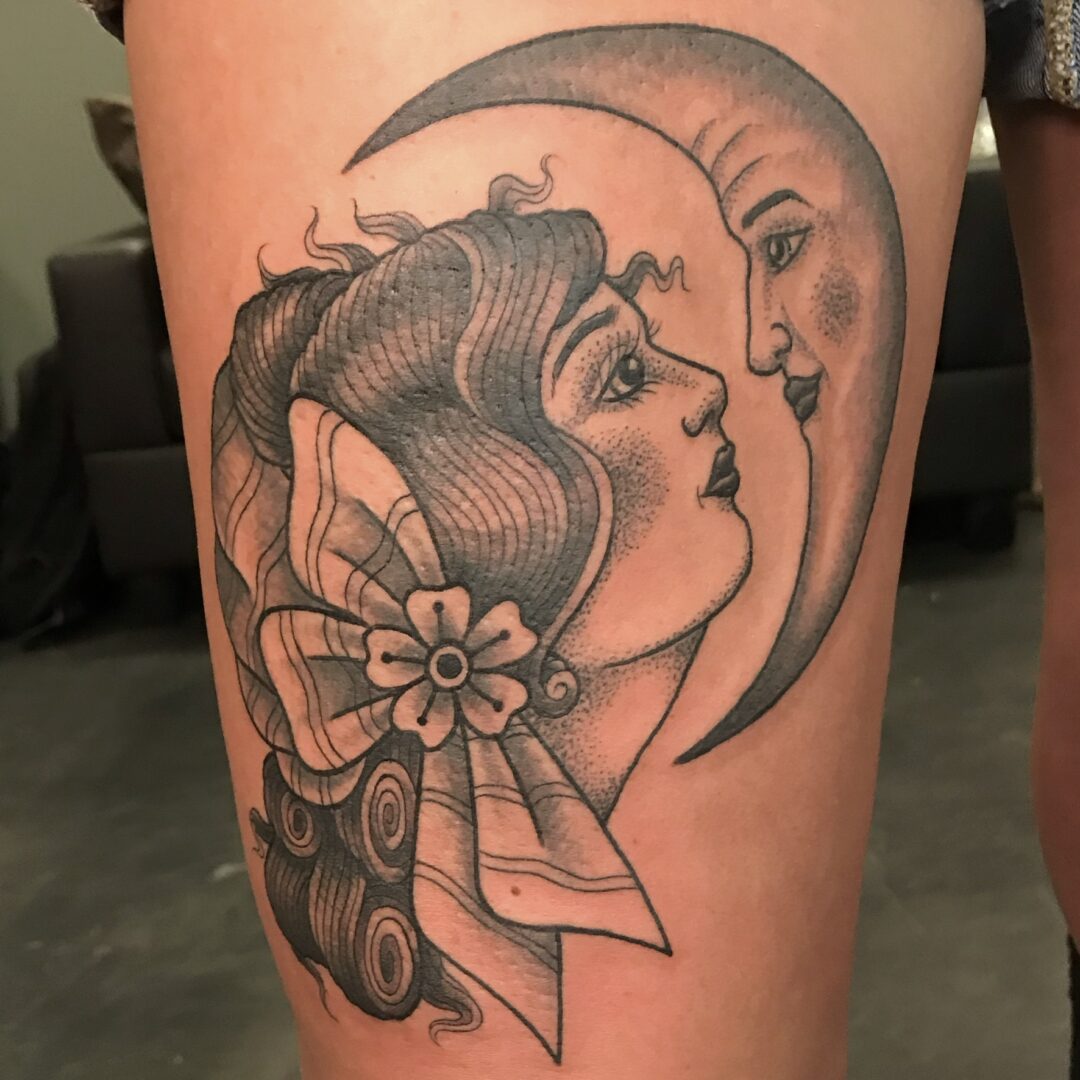 A woman with a bow and moon tattoo on her leg.