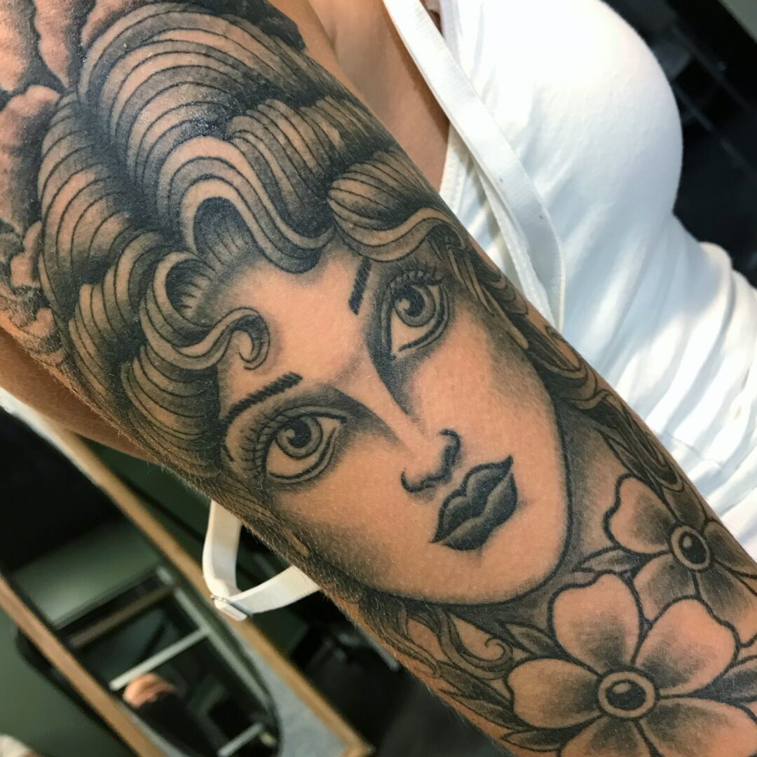 A woman with flowers in her arm tattoo.