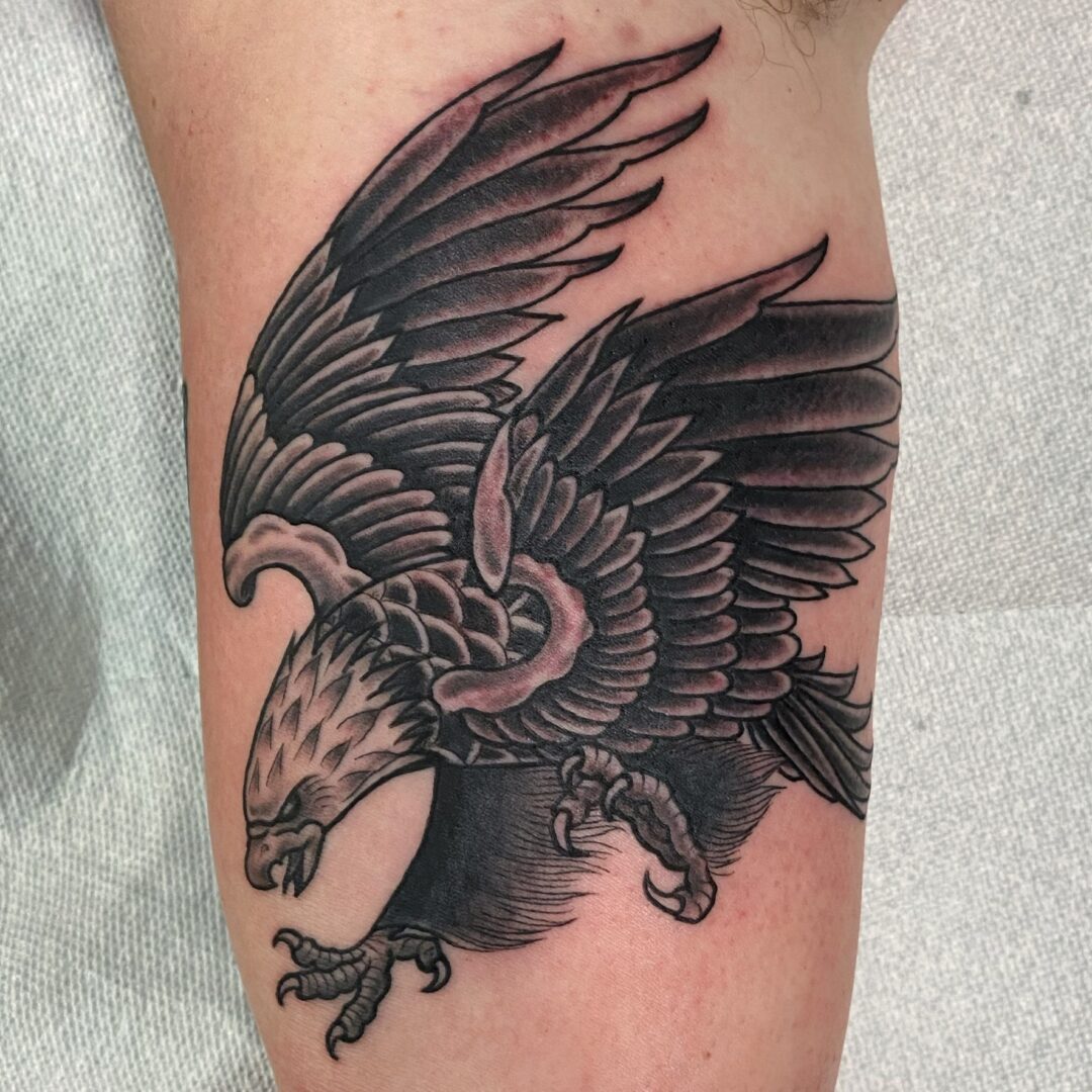 A black and grey tattoo of an eagle