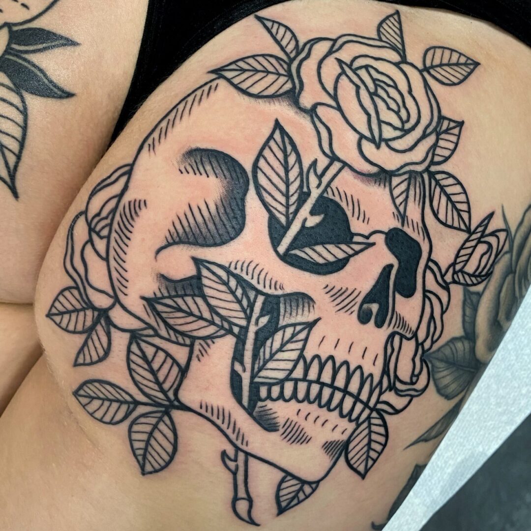 A black and white skull tattoo with roses