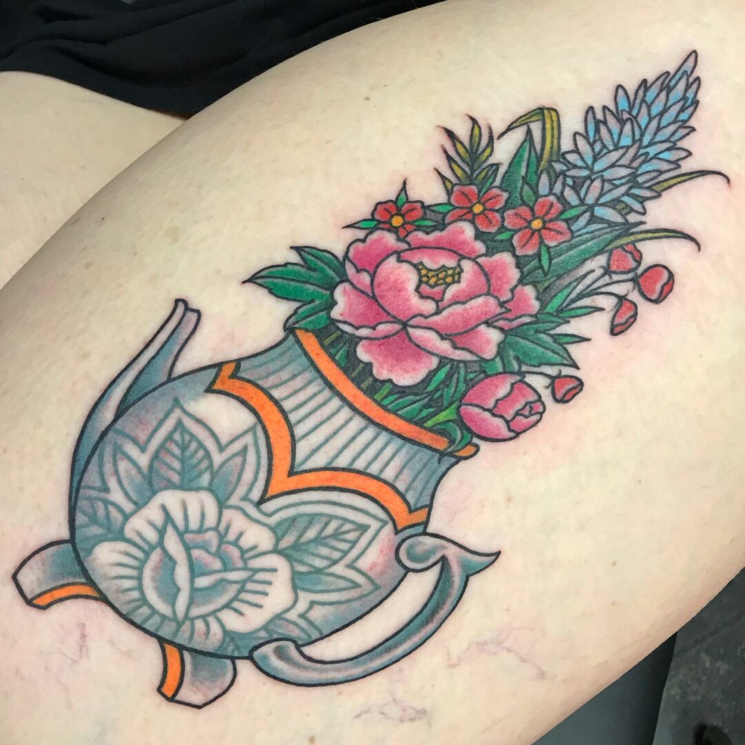 A tattoo of flowers in a vase on the arm.