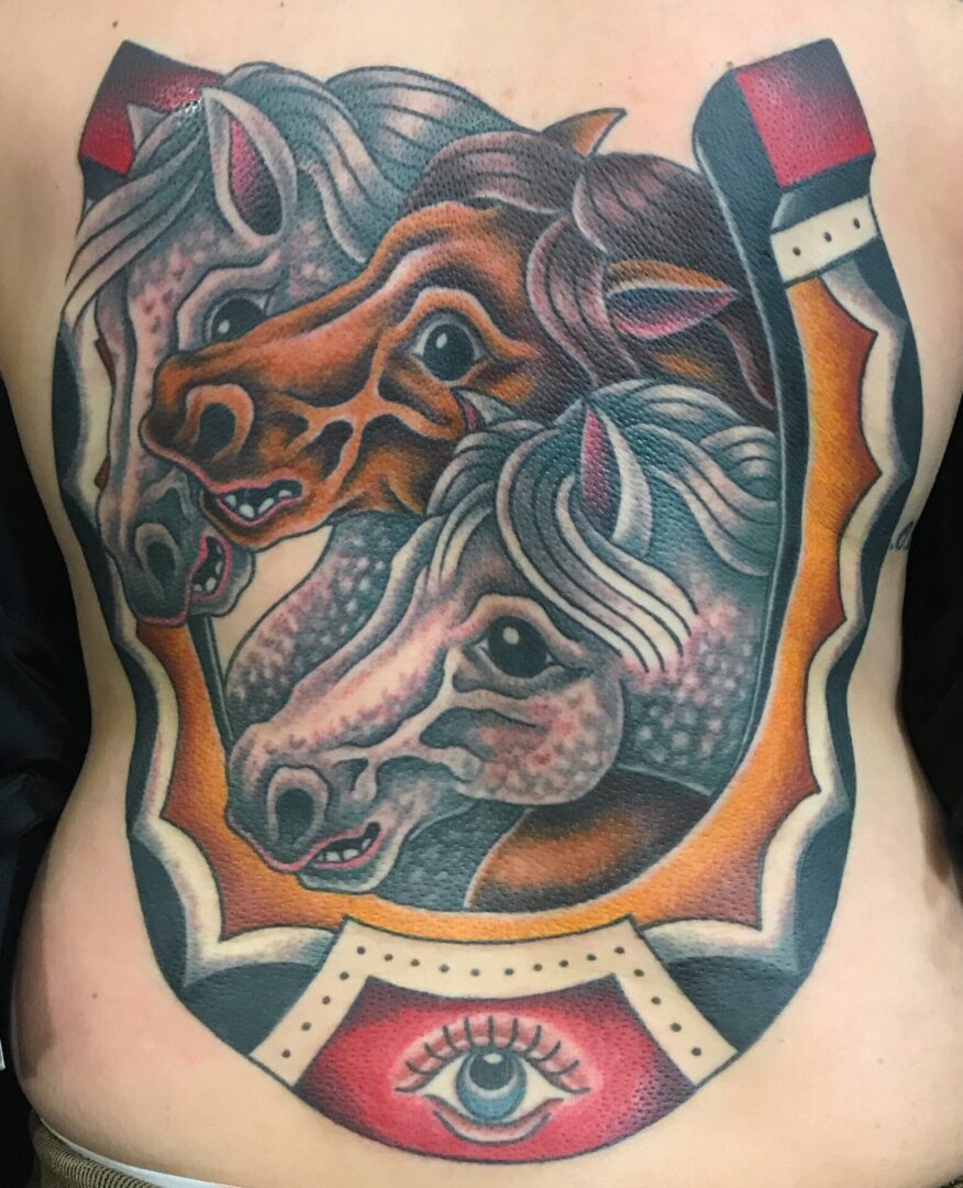 A tattoo of two horses on the back of a woman 's body.