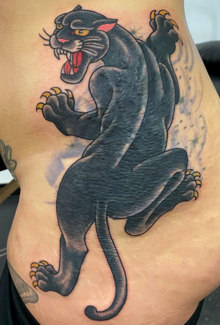 A black panther tattoo on the side of someone 's body.