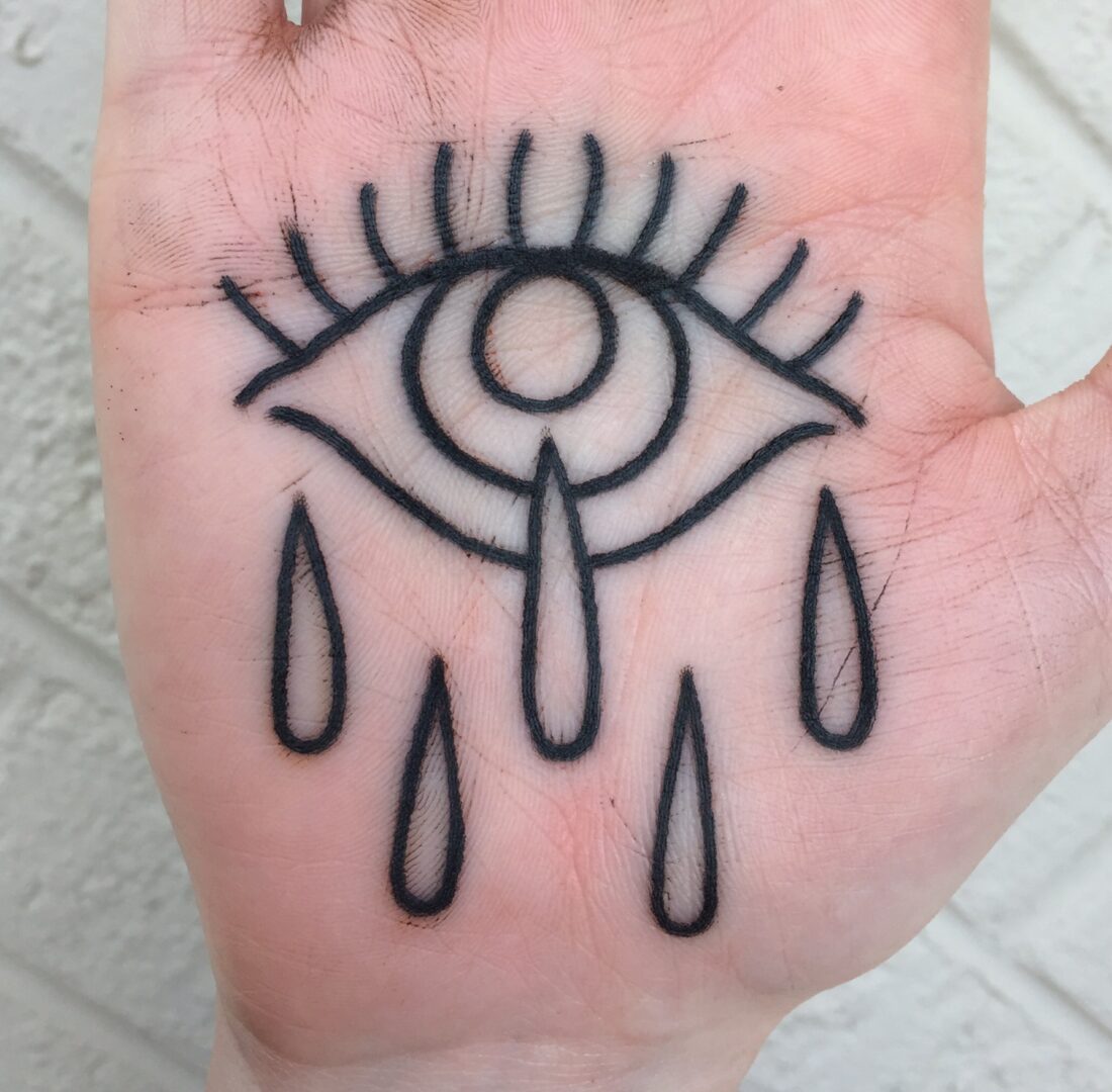 A hand with an eye and tears drawn on it.