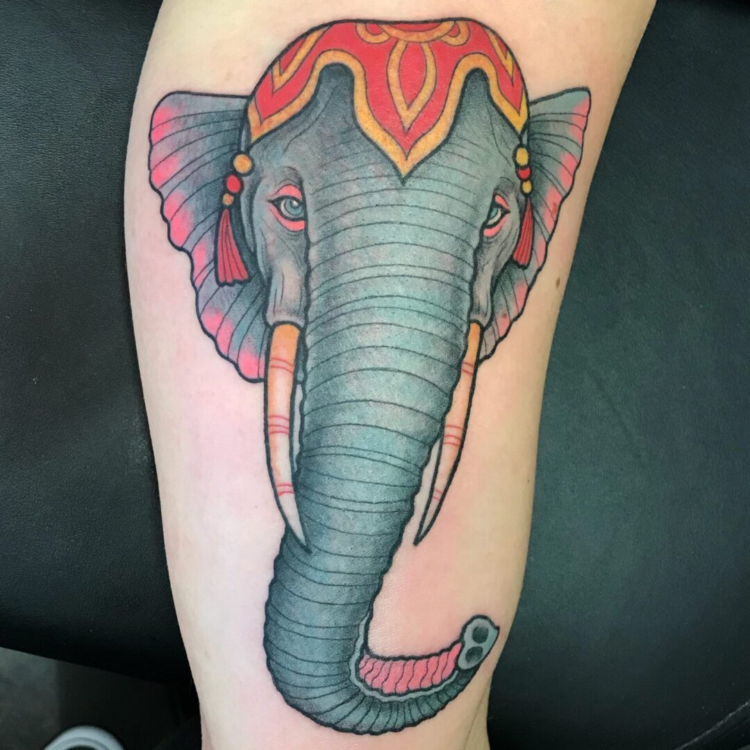 A tattoo of an elephant with red and blue colors