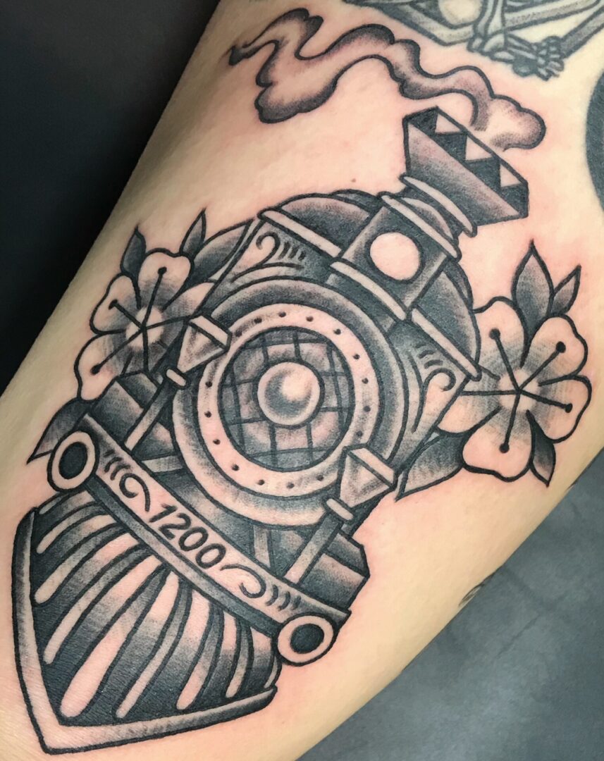 A train tattoo with flowers on it