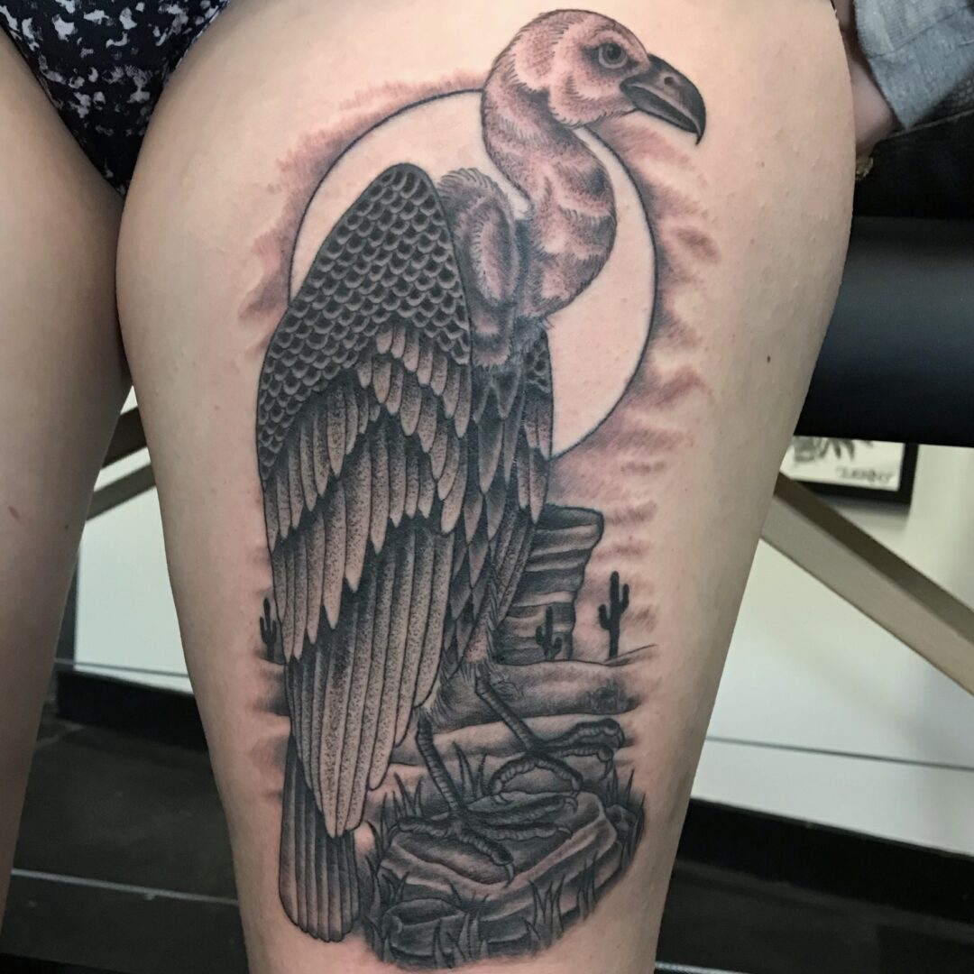 A black and white tattoo of an eagle sitting on top of a rock.