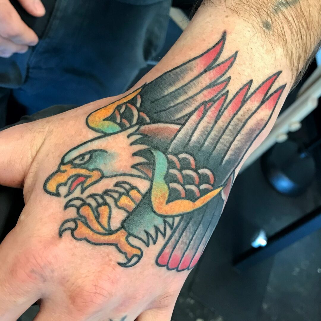 A hand with an eagle tattoo on it