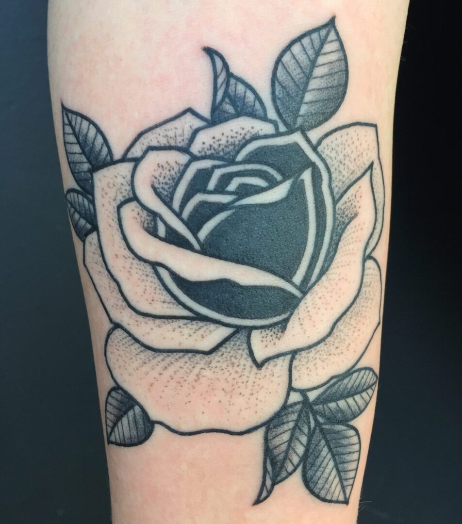 A black and white rose tattoo on the arm.