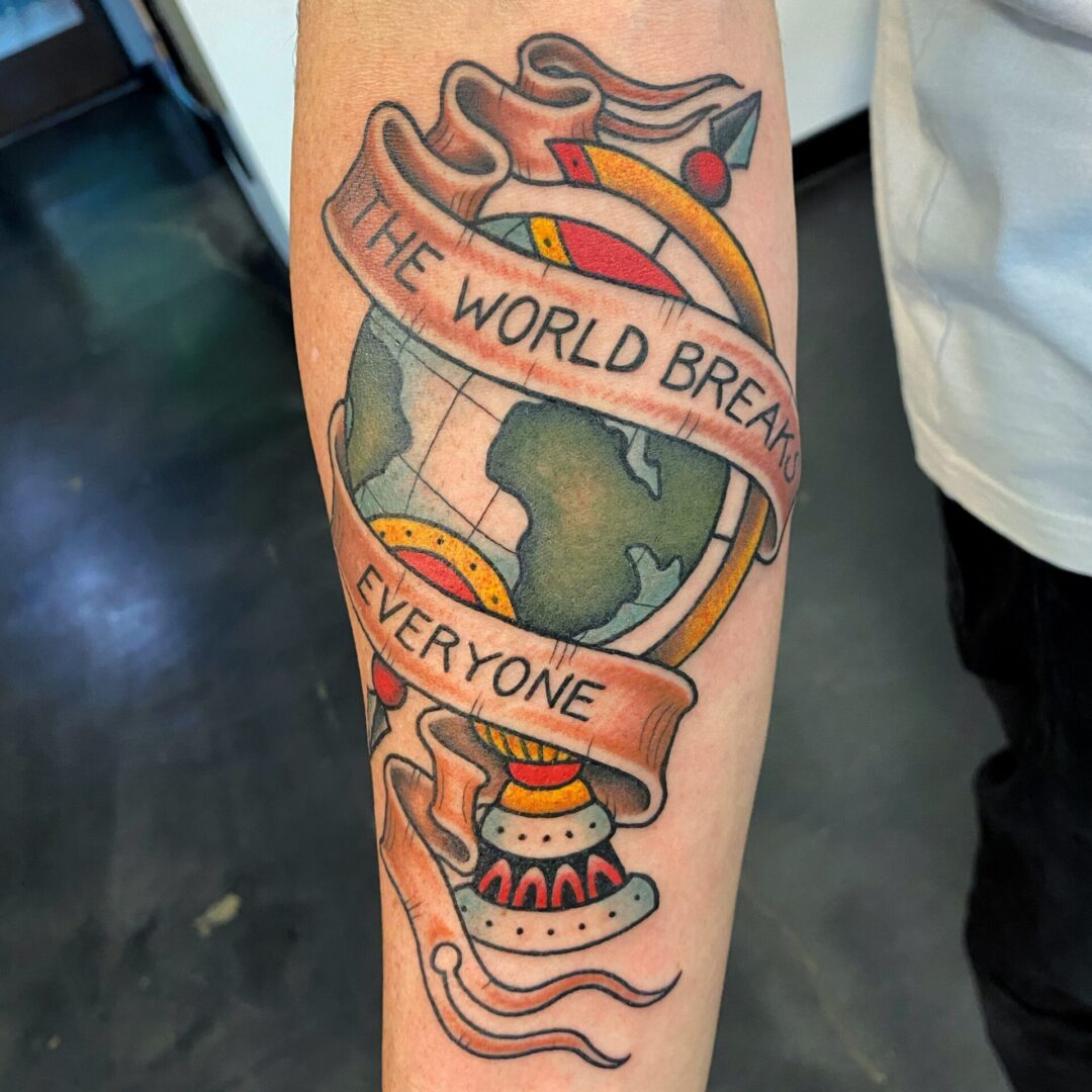 A tattoo of the world is shown on someone 's arm.
