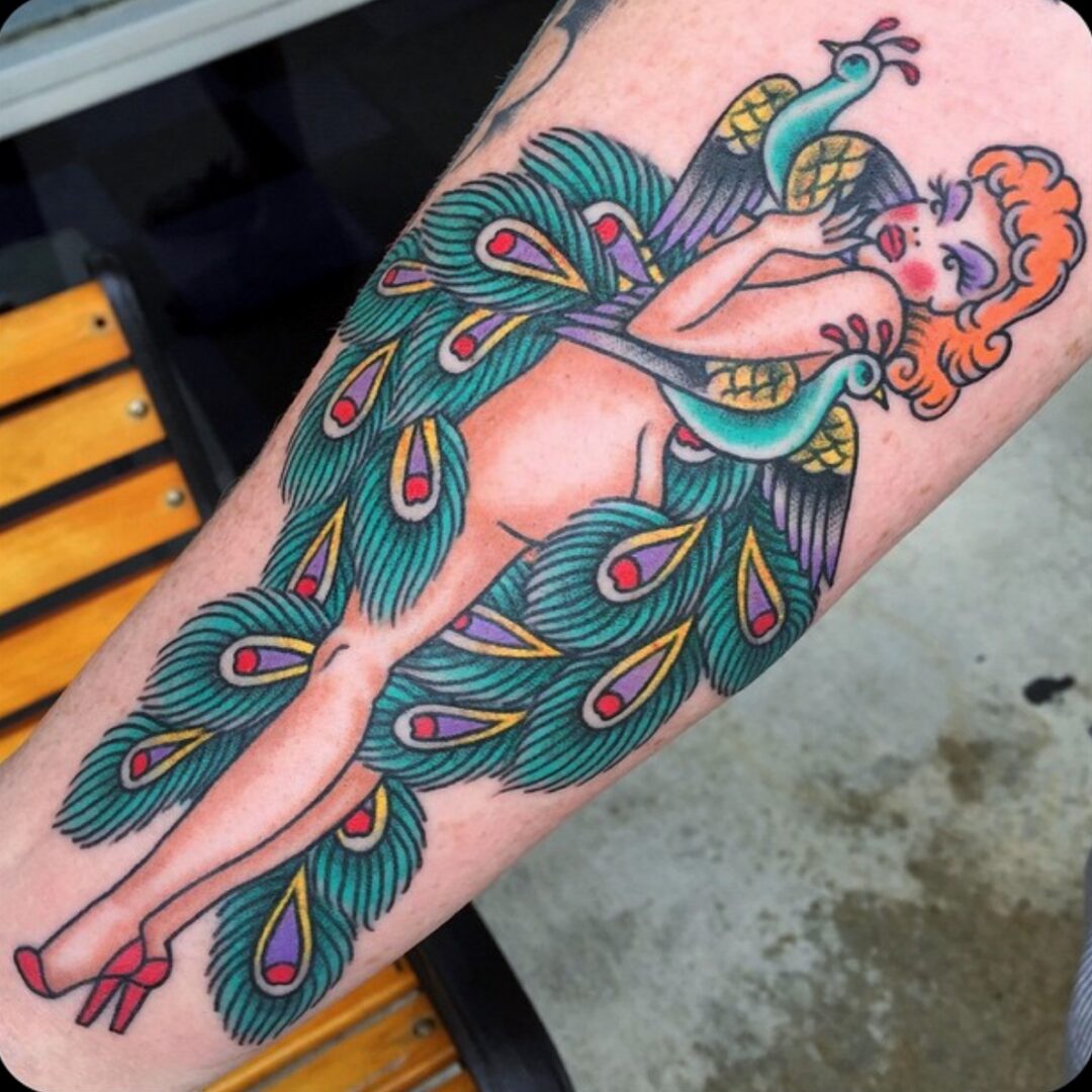 A woman with a peacock tattoo on her arm.
