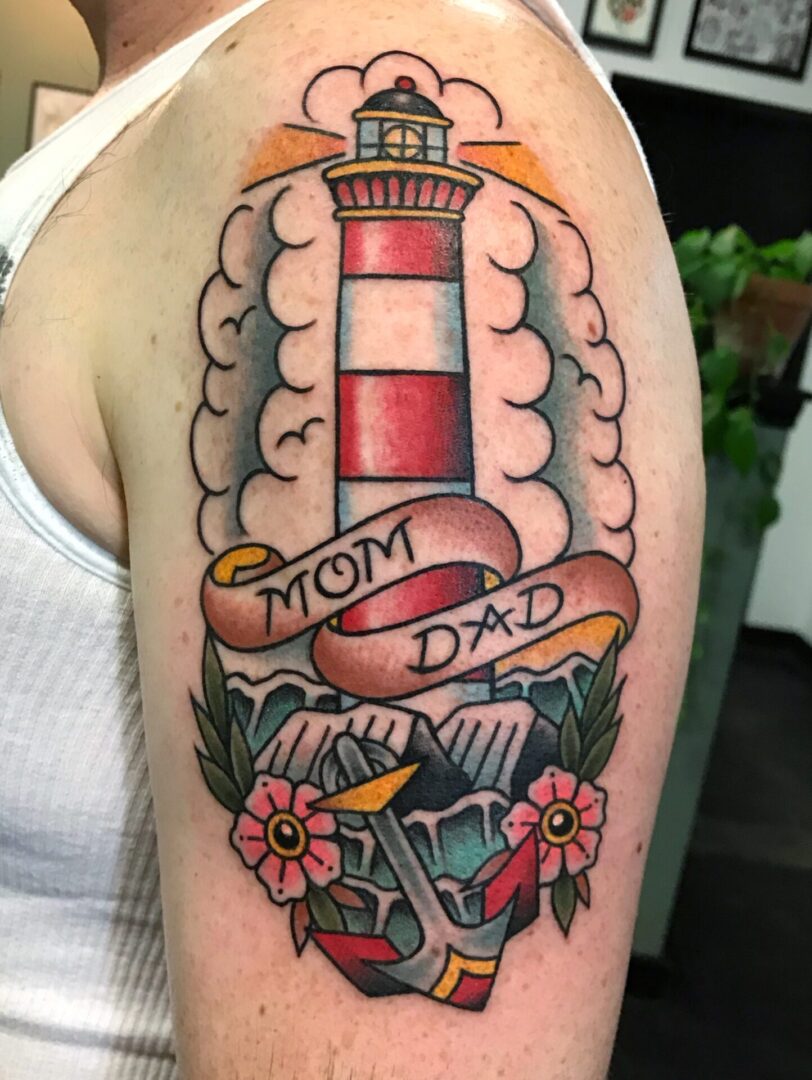 A woman with a tattoo of a lighthouse and flowers.