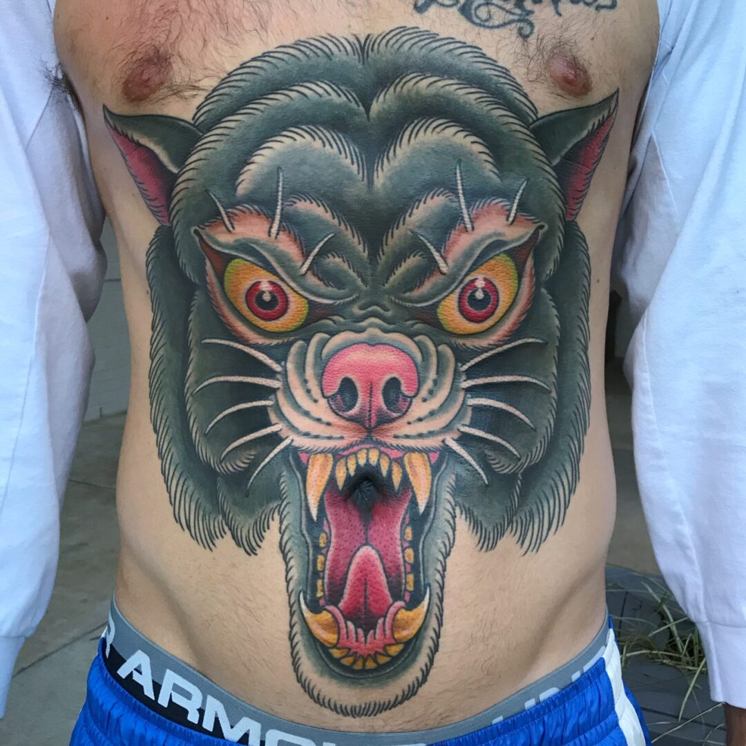 A man with a tattoo of a cat 's face.