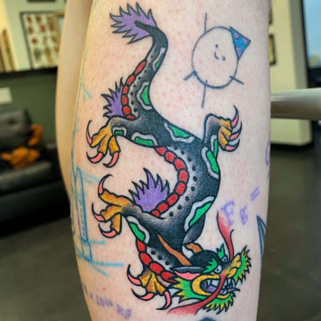 A colorful dragon tattoo on the arm of someone.