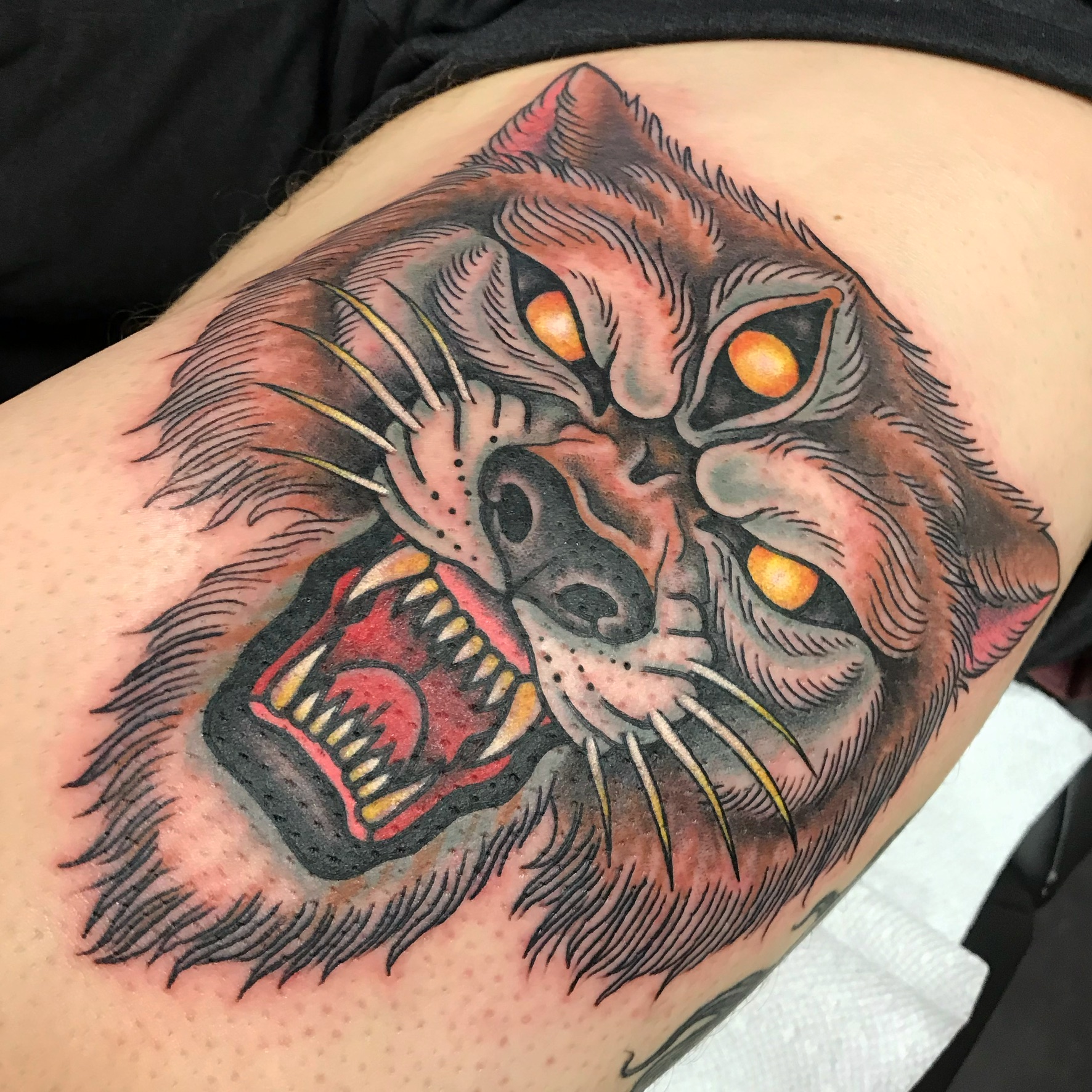 A tattoo of a wolf with yellow eyes