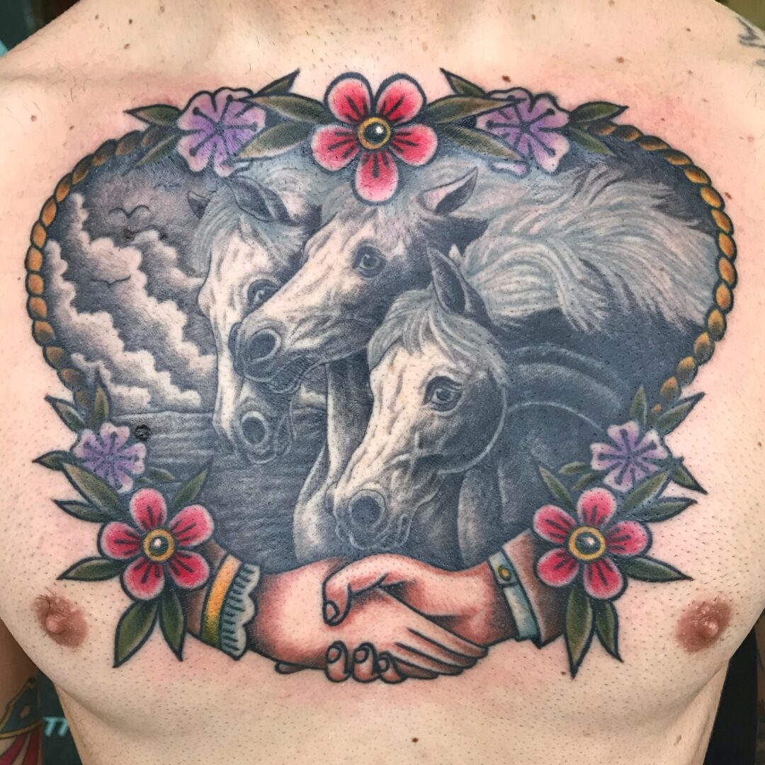 A man with a tattoo of horses and flowers.