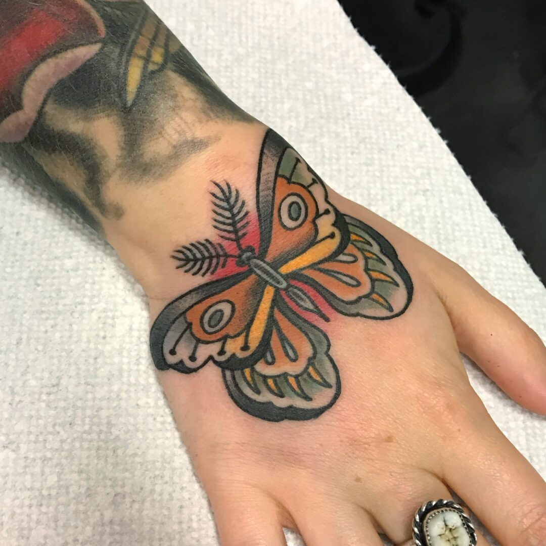 A hand with a butterfly tattoo on it