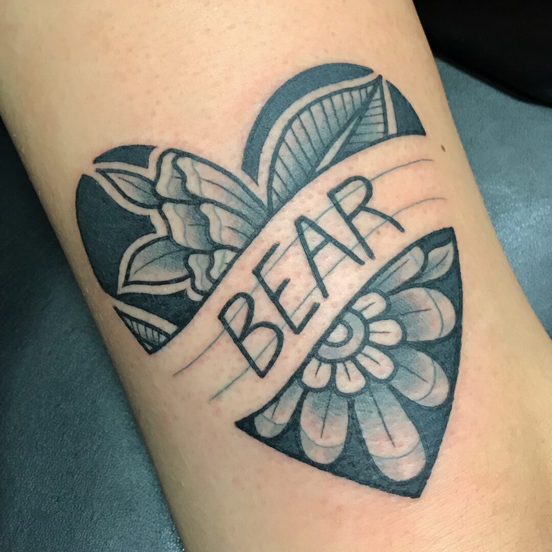 A tattoo of the word bear on a heart.