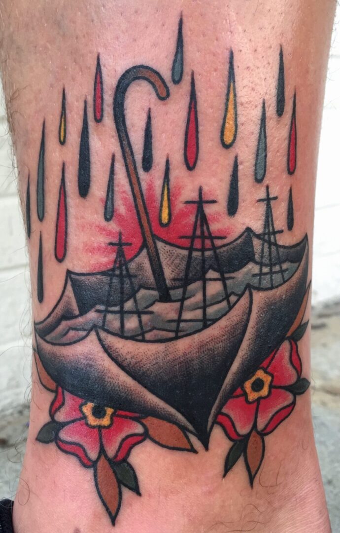A tattoo of an umbrella with boats in it