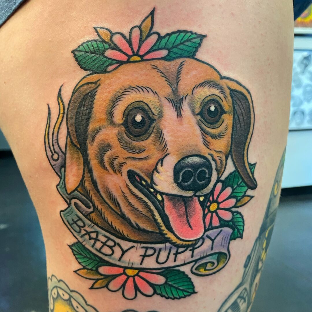 A tattoo of a dog with flowers on it.