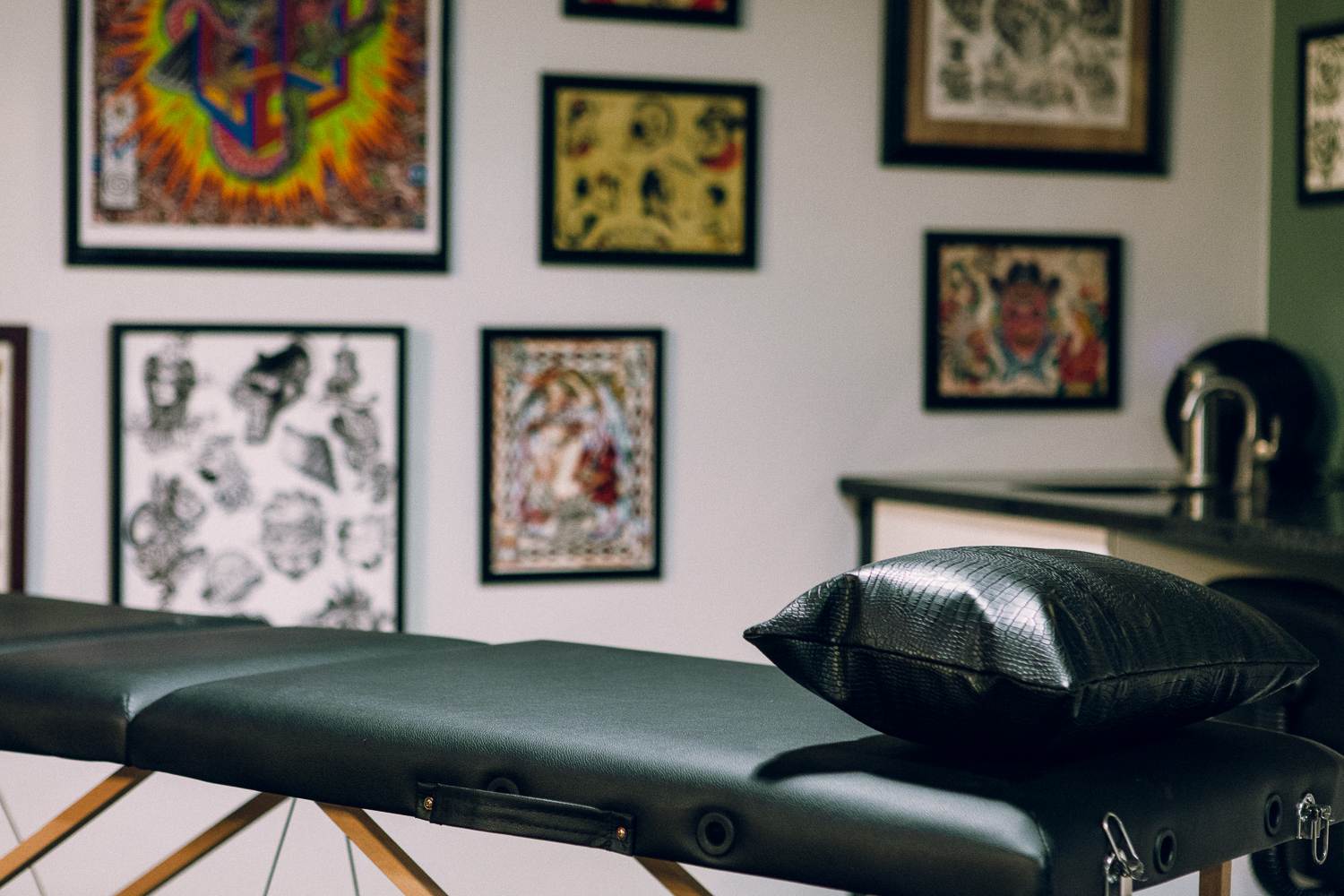 A tattoo parlor with many tattoos on the wall.