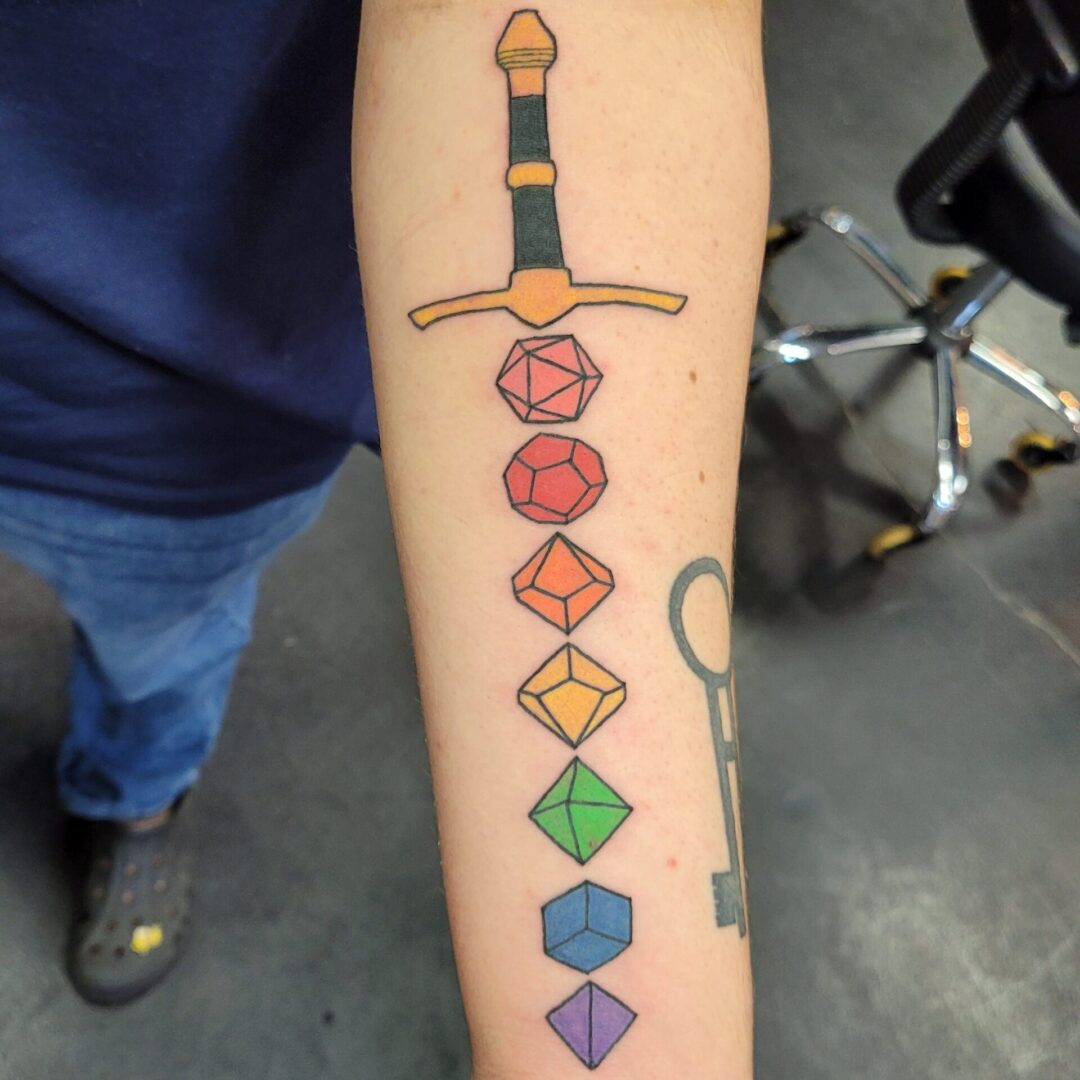 A tattoo of a sword and dice is shown.