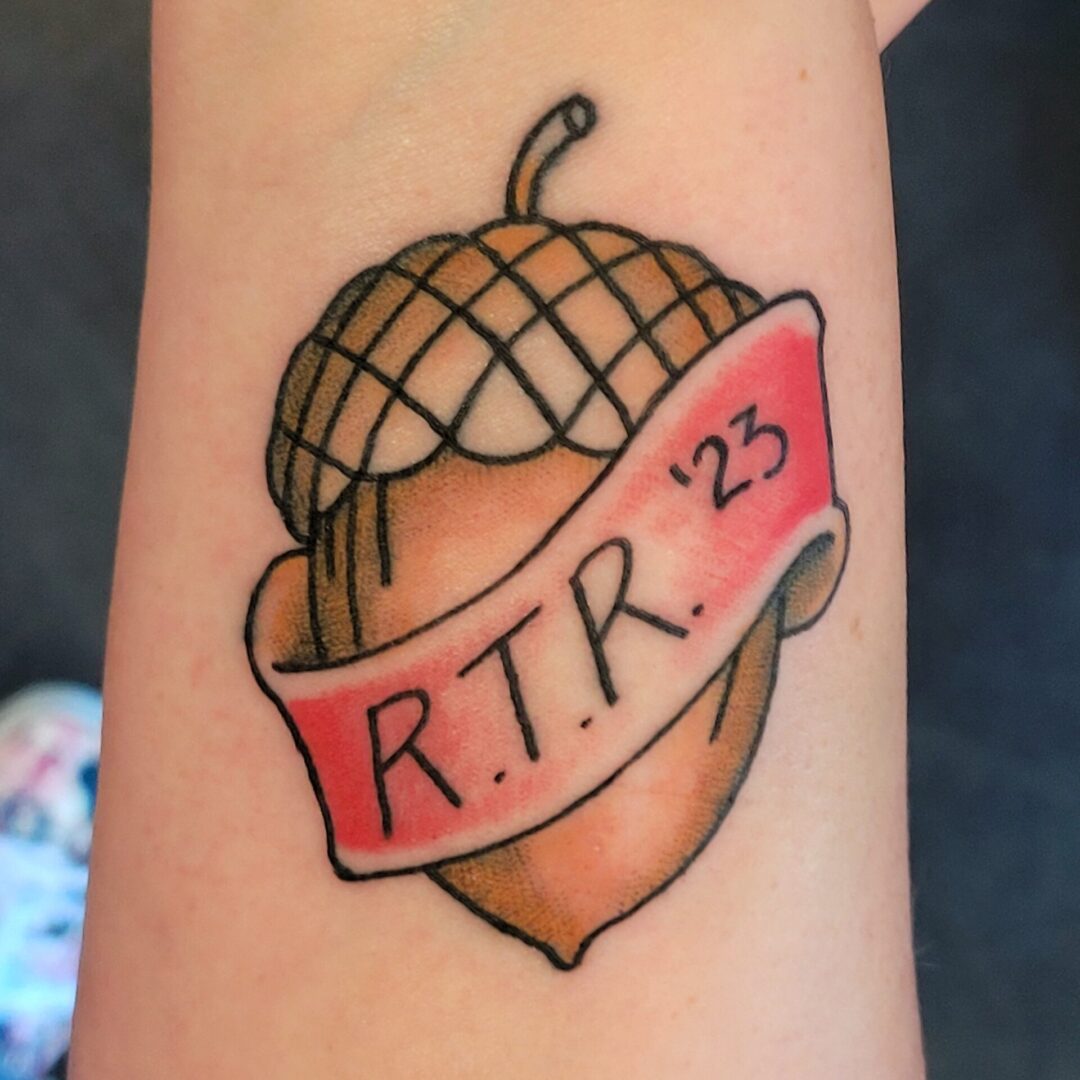 A tattoo of an acorn with the name 