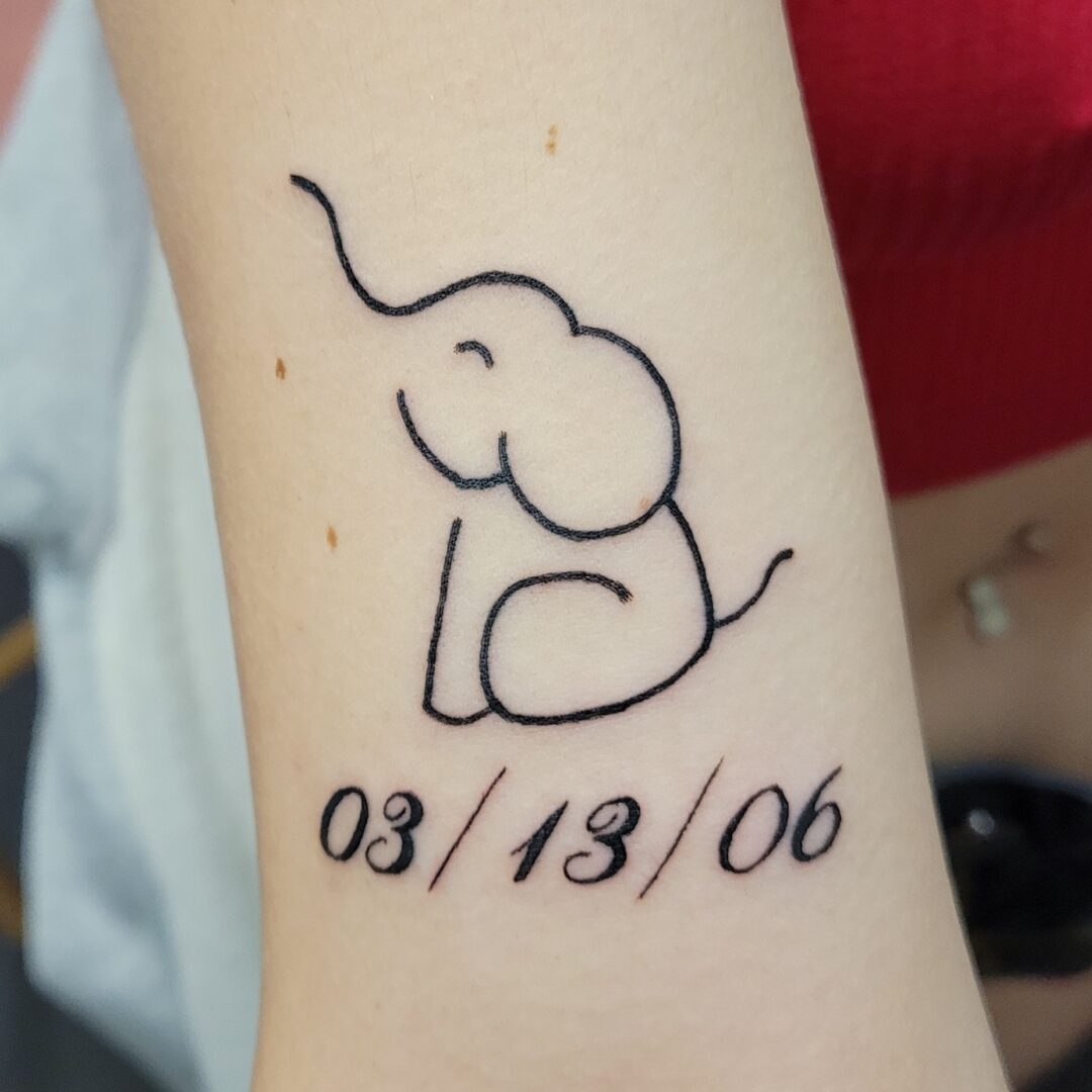 A tattoo of an elephant with date and time.