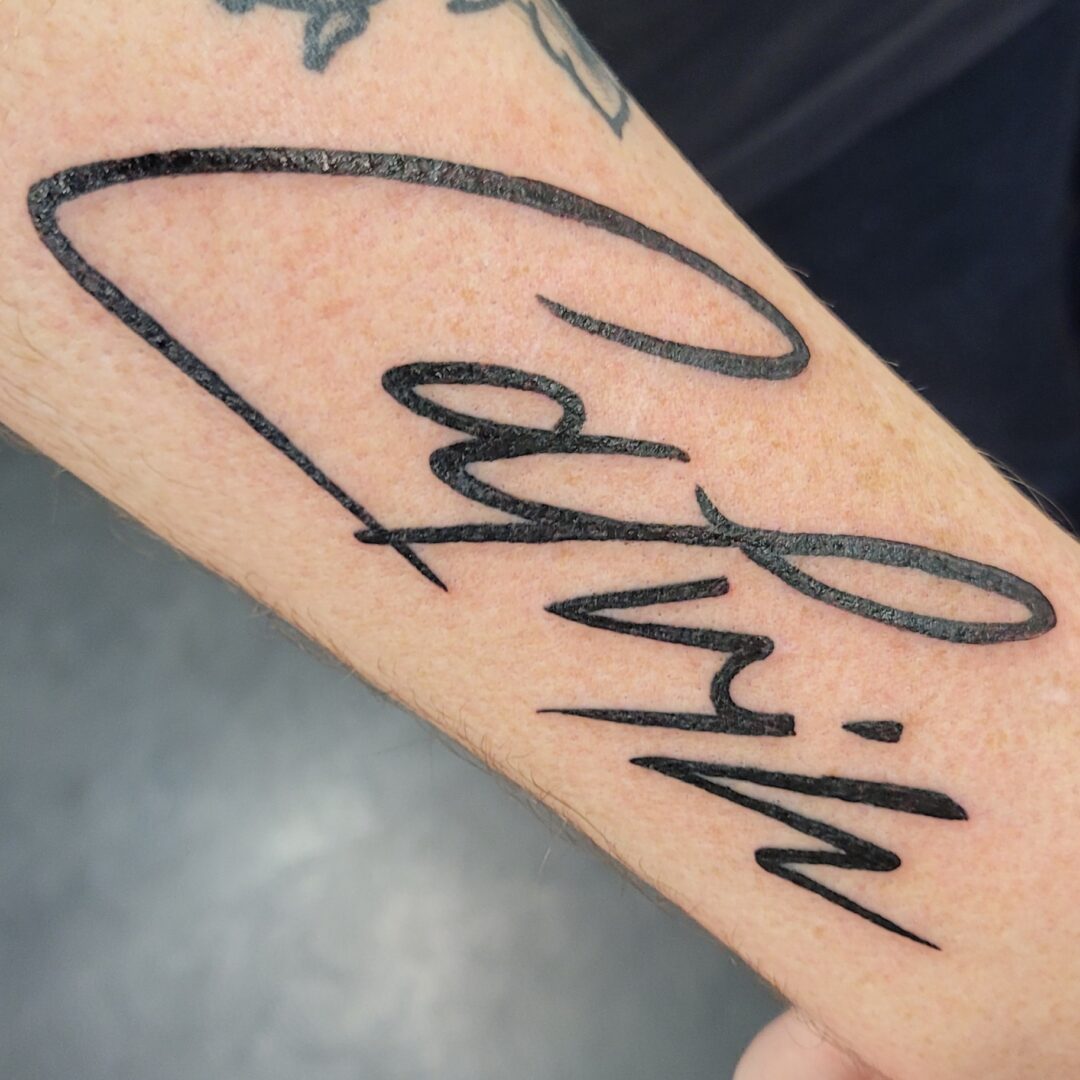 A person 's arm with the name calvin written in black ink.
